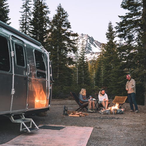 Karen Blue and her family sitting around a fire while boondocking in a forest