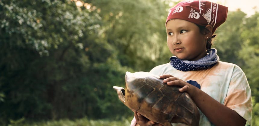 A girl scout holding the shell of a turtle