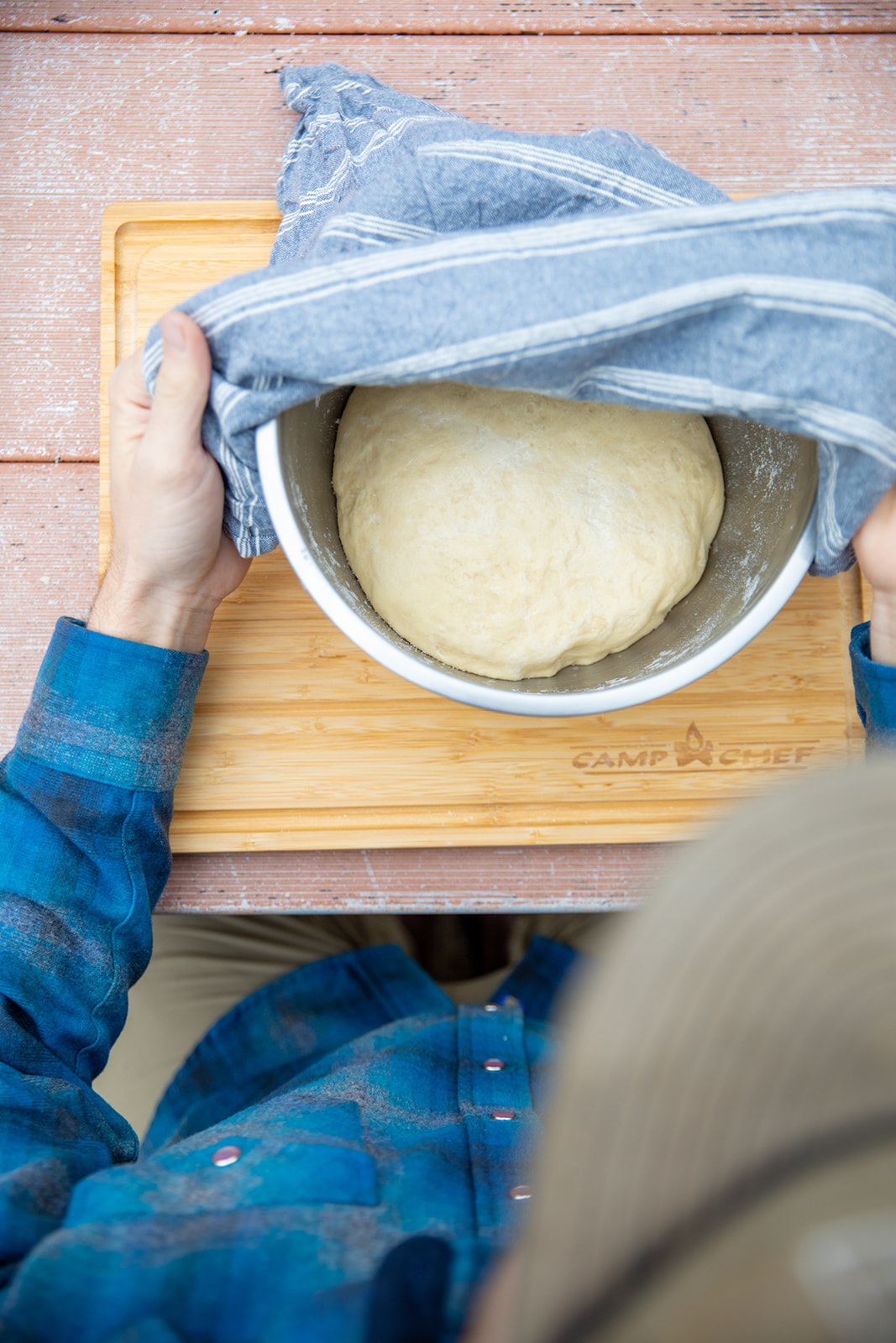 Letting dough rise in a bowl covered with a towel. 