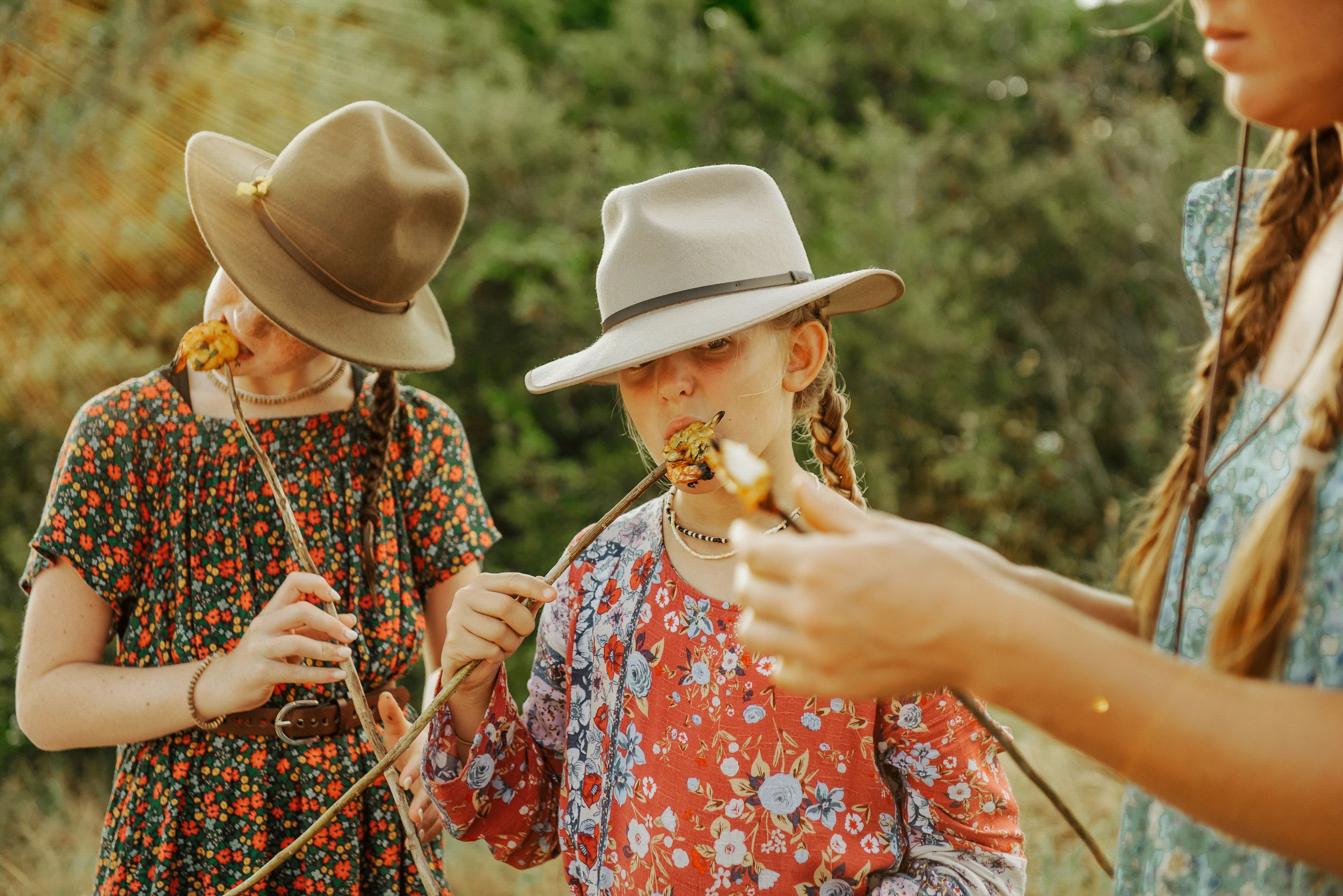 Girls eating shrimp cooked on sticks