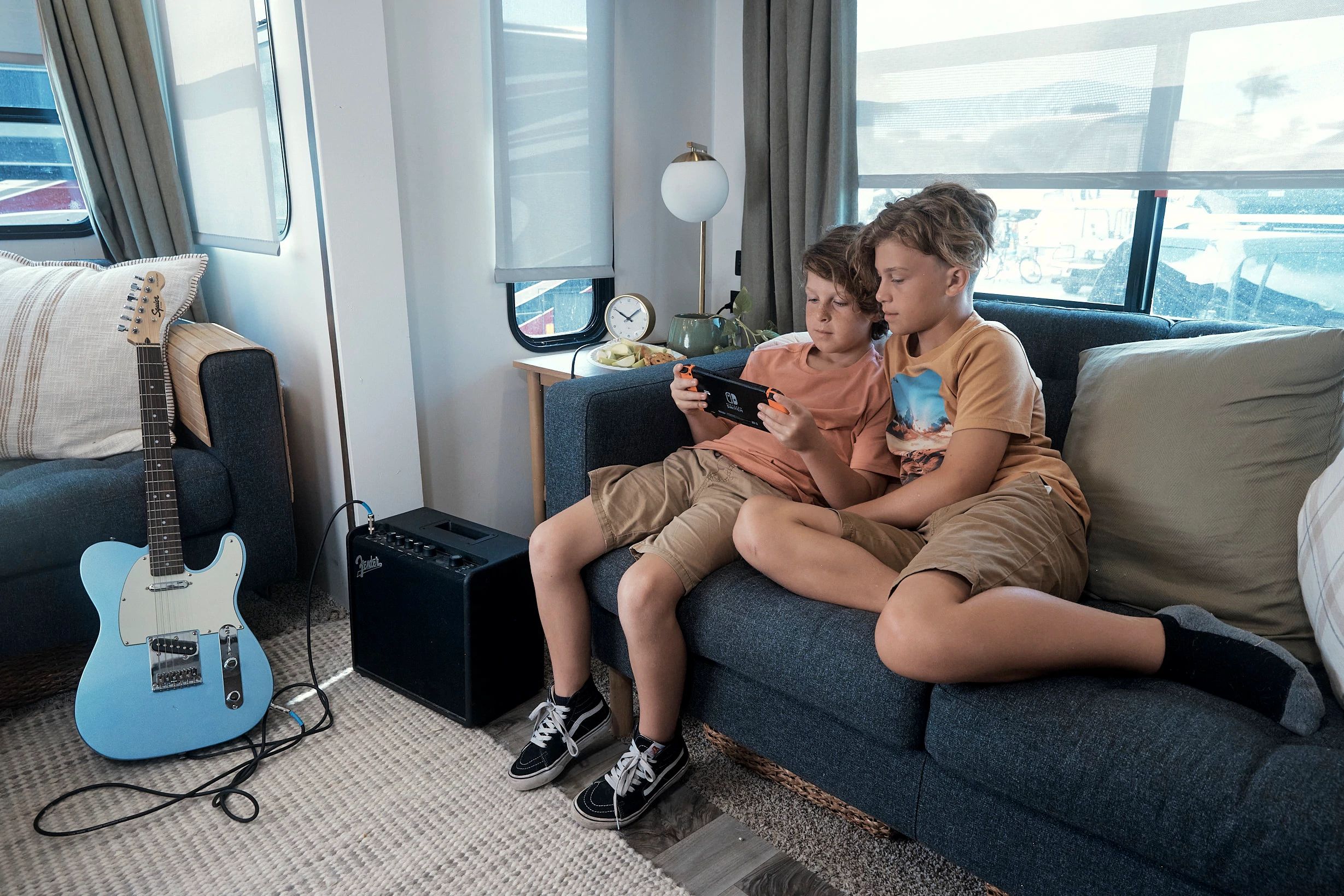 The Lane Boys play video games on the couch in the living room of their RV