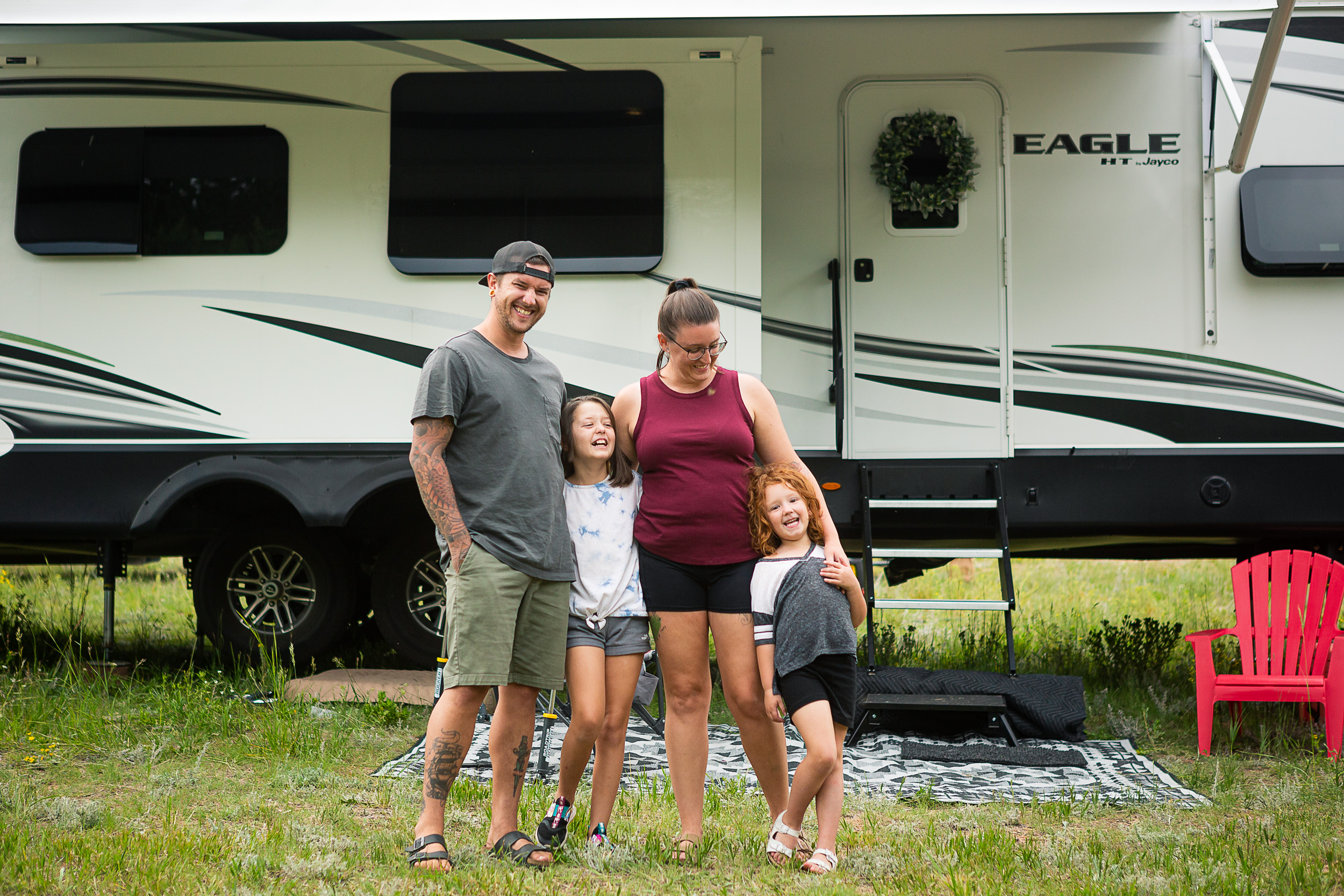 A family portrait of the Robersons in front of their Jayco Eagle