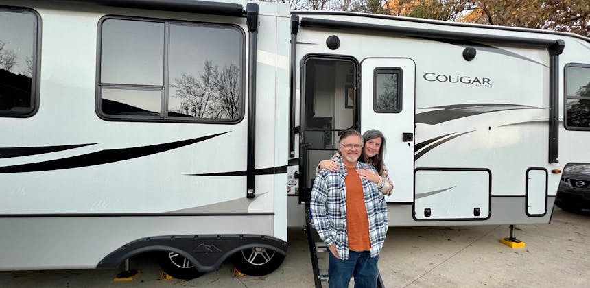 Donny and Tammy Benedict pose outside of their Keystone Cougar.