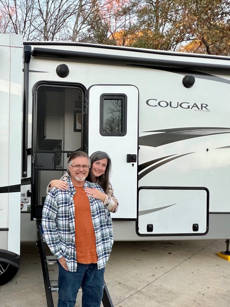 Donny and Tammy Benedict pose outside of their Keystone Cougar.