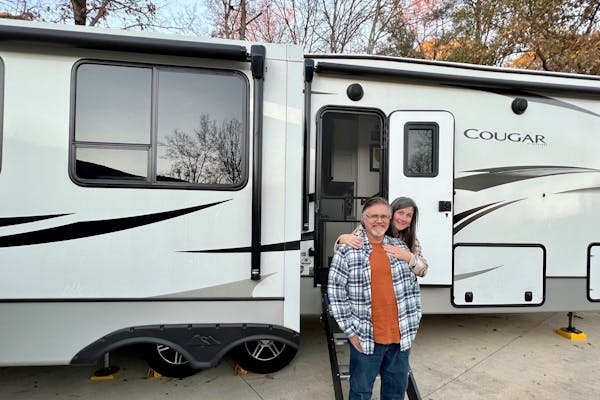 Donny and Tammy Benedict pose outside of their Keystone Cougar.