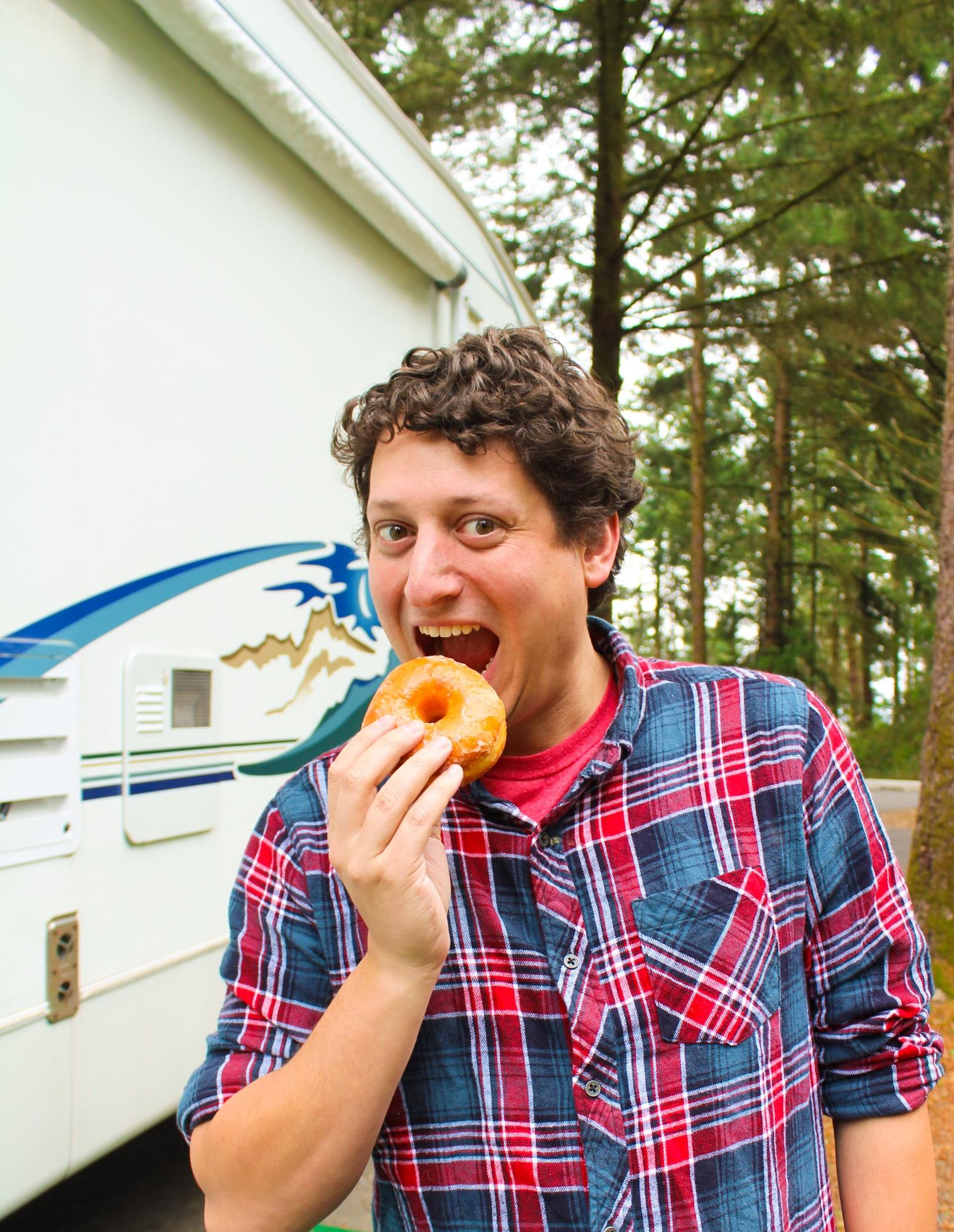 Jesse Lyons about to take a bite of a donut in front of his Keystone Cougar.