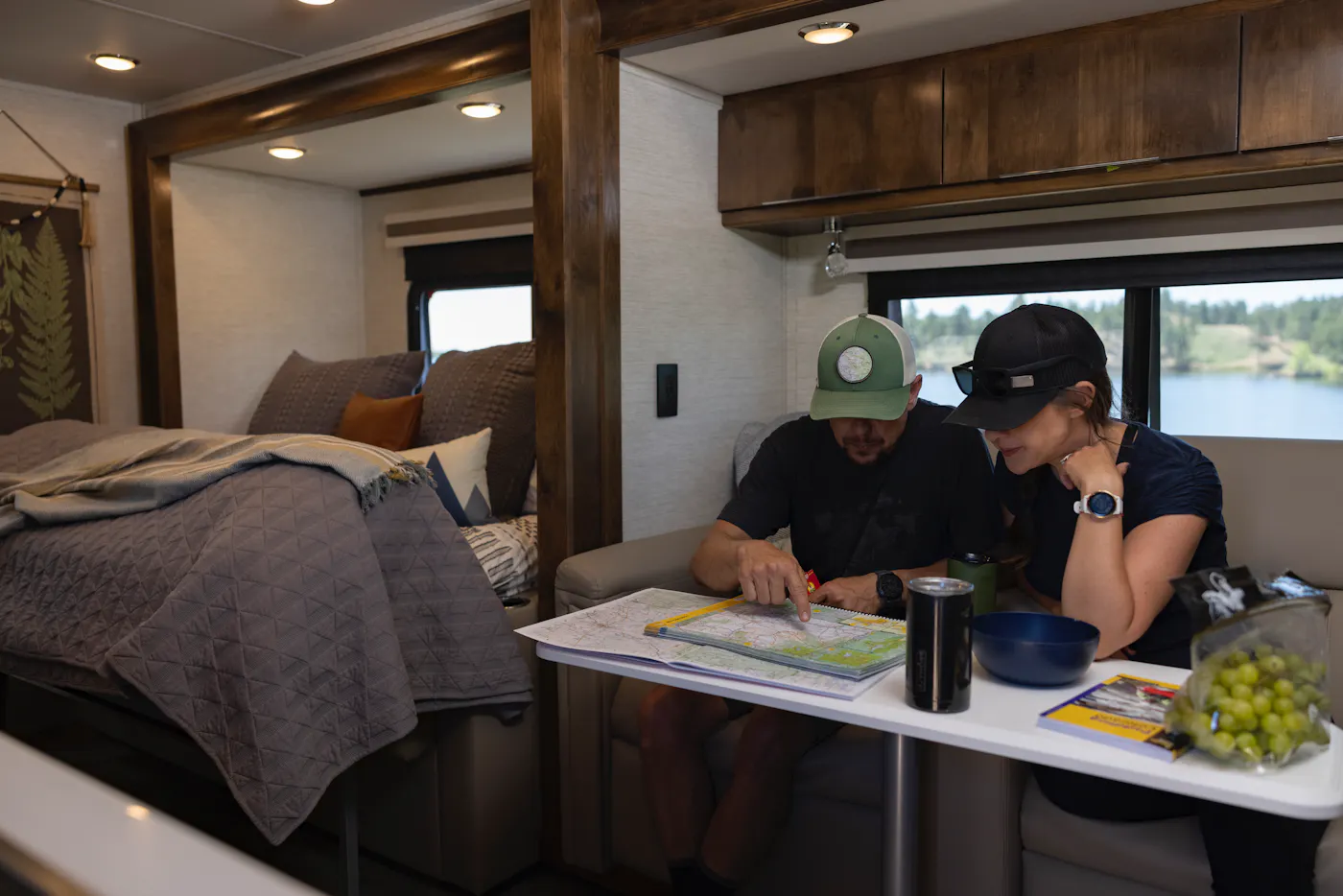 Dustin and Sarah look at a map sitting in the dinette inside their Tiffin Wayfarer