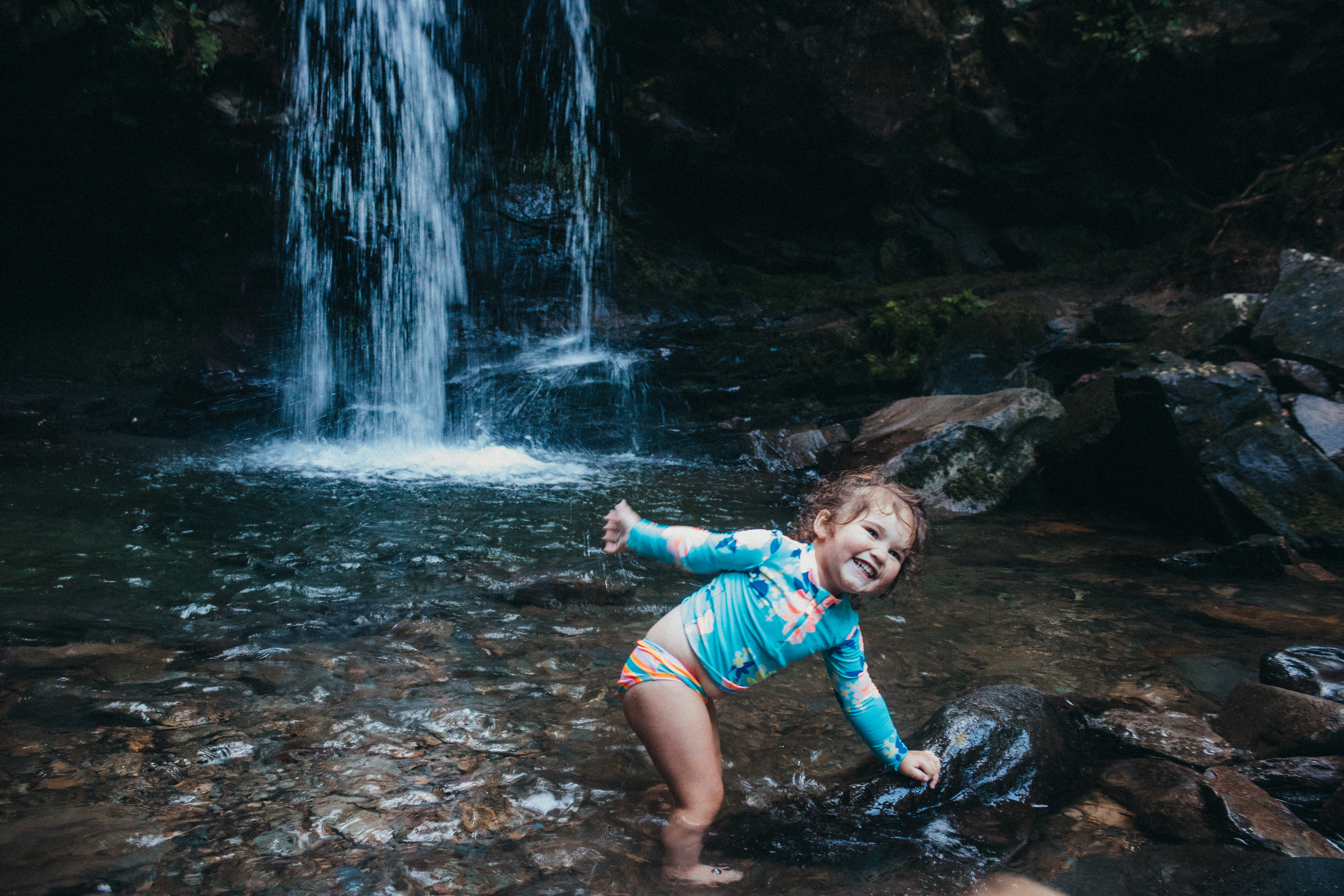 Sammy Seles' young daughter plays in water near a waterfall.