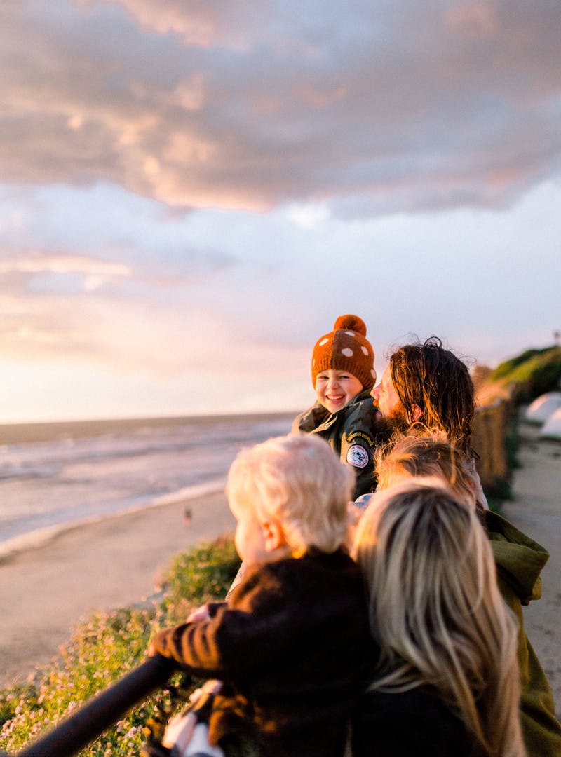 Amber Thrane and her family watching the sun set over the beach and ocean