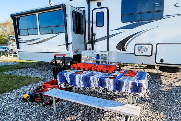 STEVE & KAYLEE TECHAU's RV with tools on a picnic bench