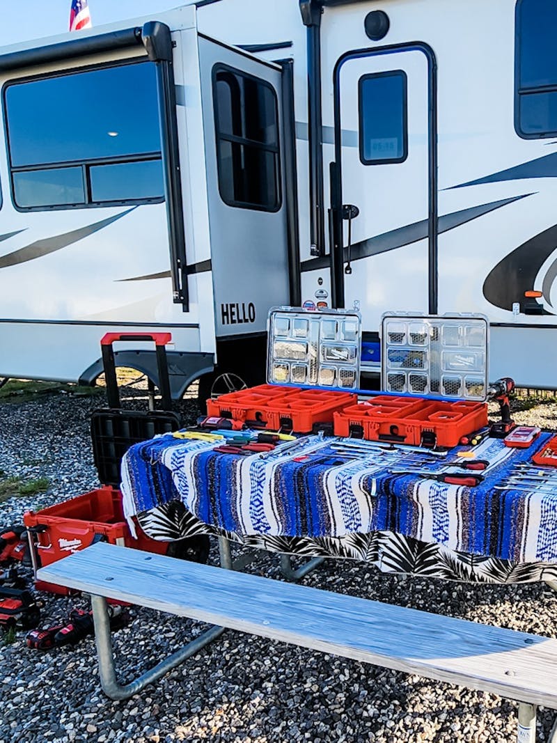 STEVE & KAYLEE TECHAU's RV with tools on a picnic bench