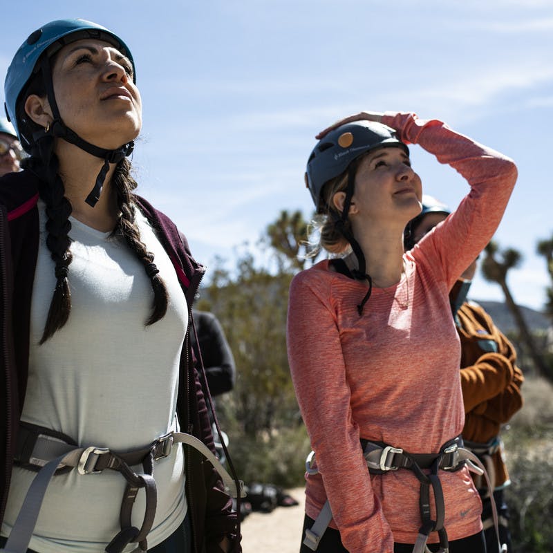 Participants look up at the rock formation they will climb.