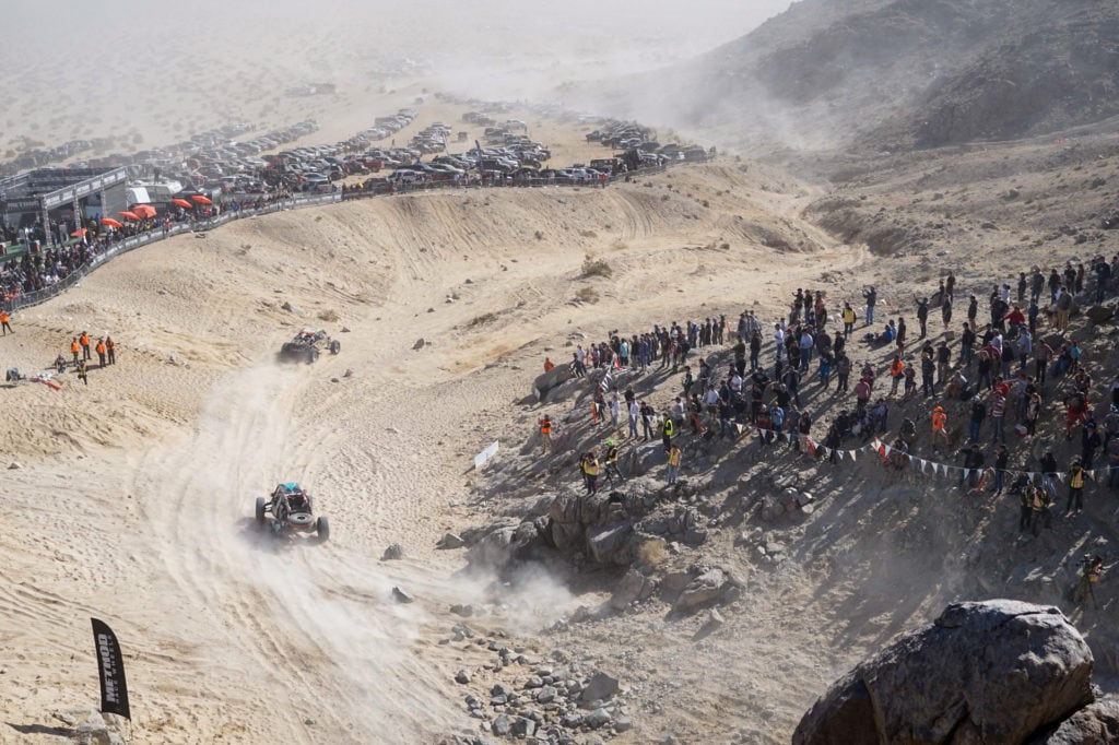 Ultra4 vehicle rounding a section of the path while spectators watch.