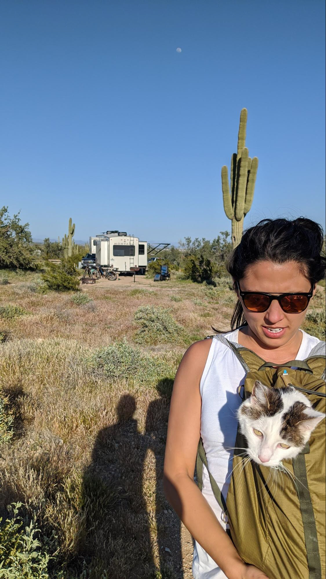 Brittany Ciepluch holding her cat in her backpack while going on a hike near their Keystone Montana fifth wheel.