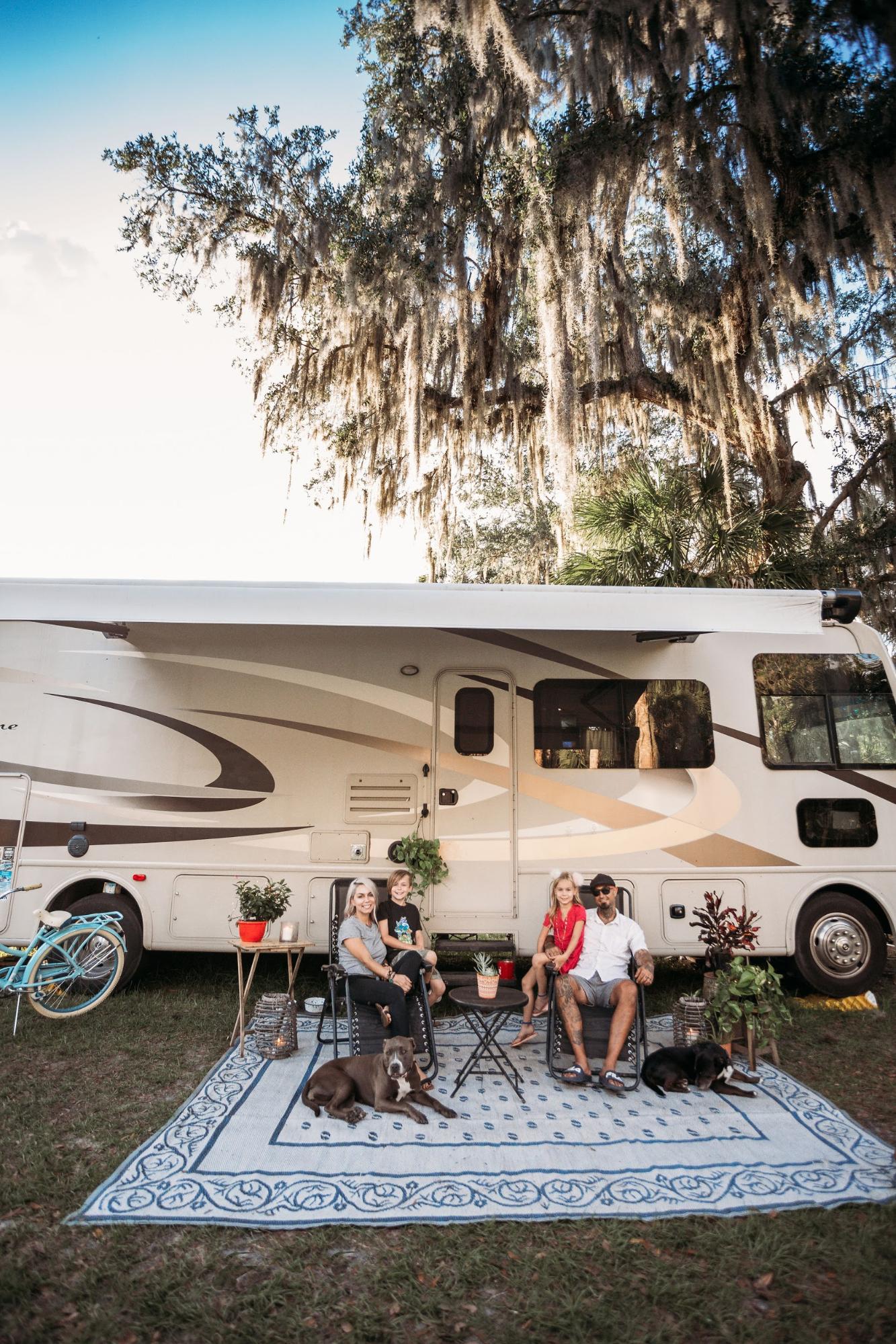 Justin Russell and his family pose for a picture in front of their 2016 Thor Hurricane Class A RV.