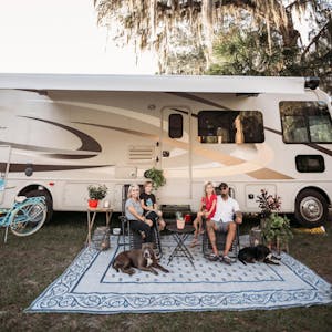 Justin Russell and his family pose for a picture in front of their 2016 Thor Hurricane Class A RV.
