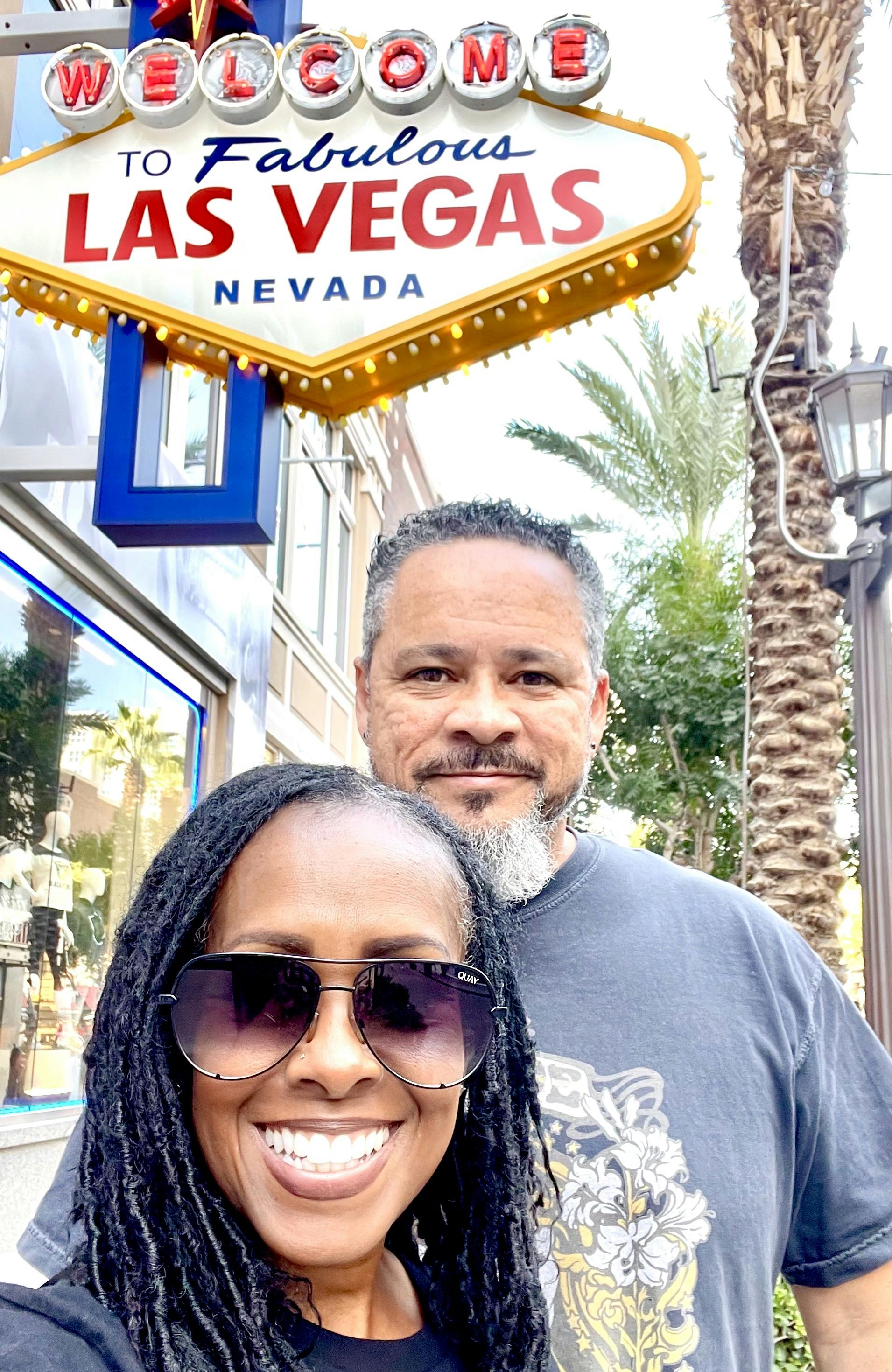 Robin and Warren Baxter in front of the welcome to Las Vegas sign