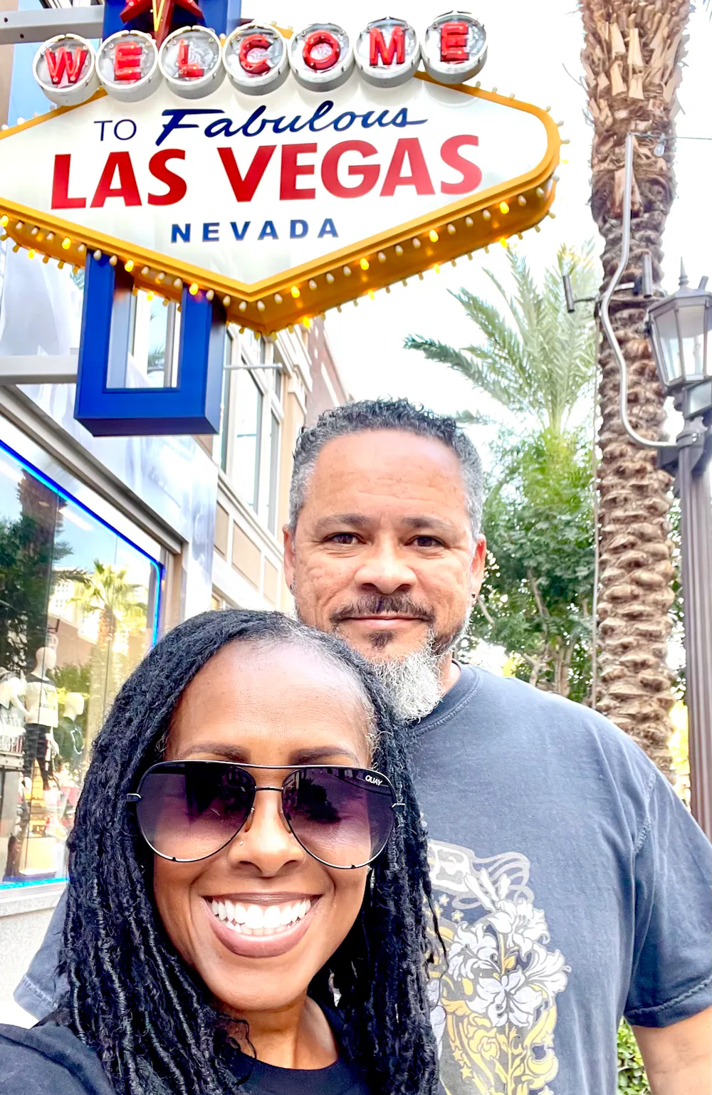 Robin and Warren Baxter in front of the welcome to Las Vegas sign