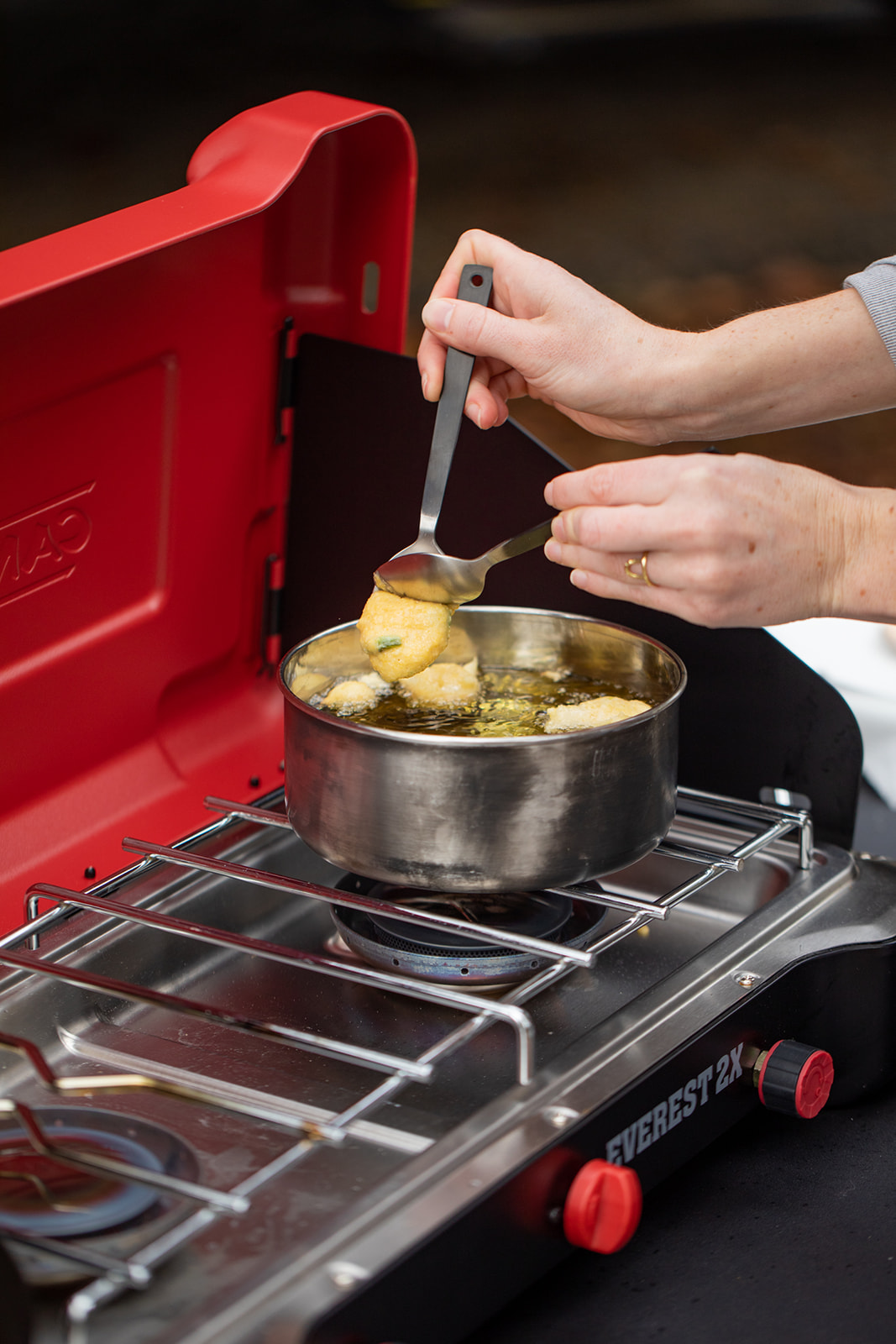Dropping hush puppy batter into hot oil. 