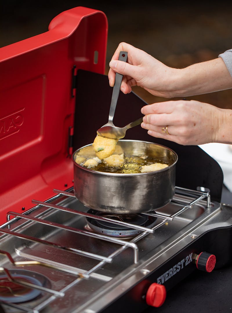 Dropping hush puppy batter into hot oil.
