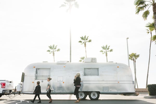 Amber thrane and her children walking in front of an Airstream RV.