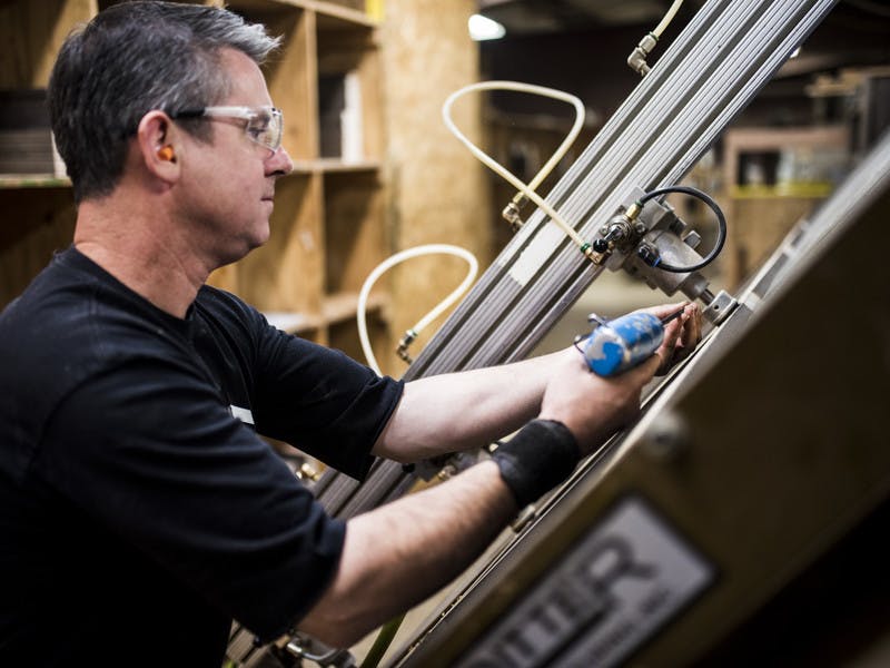 Factory worker installing glass