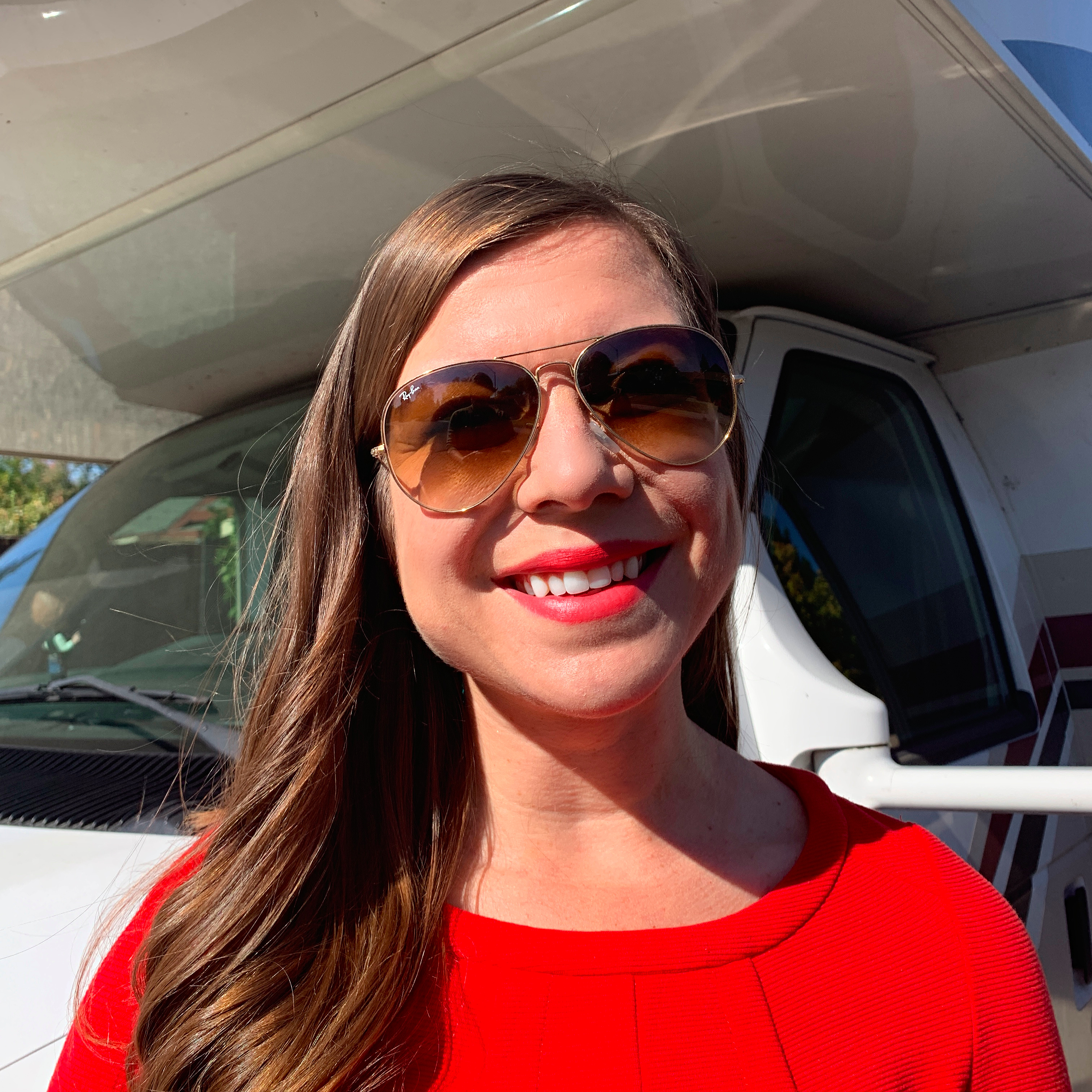 A headshot of Sarah Hubbart in front of her RV.