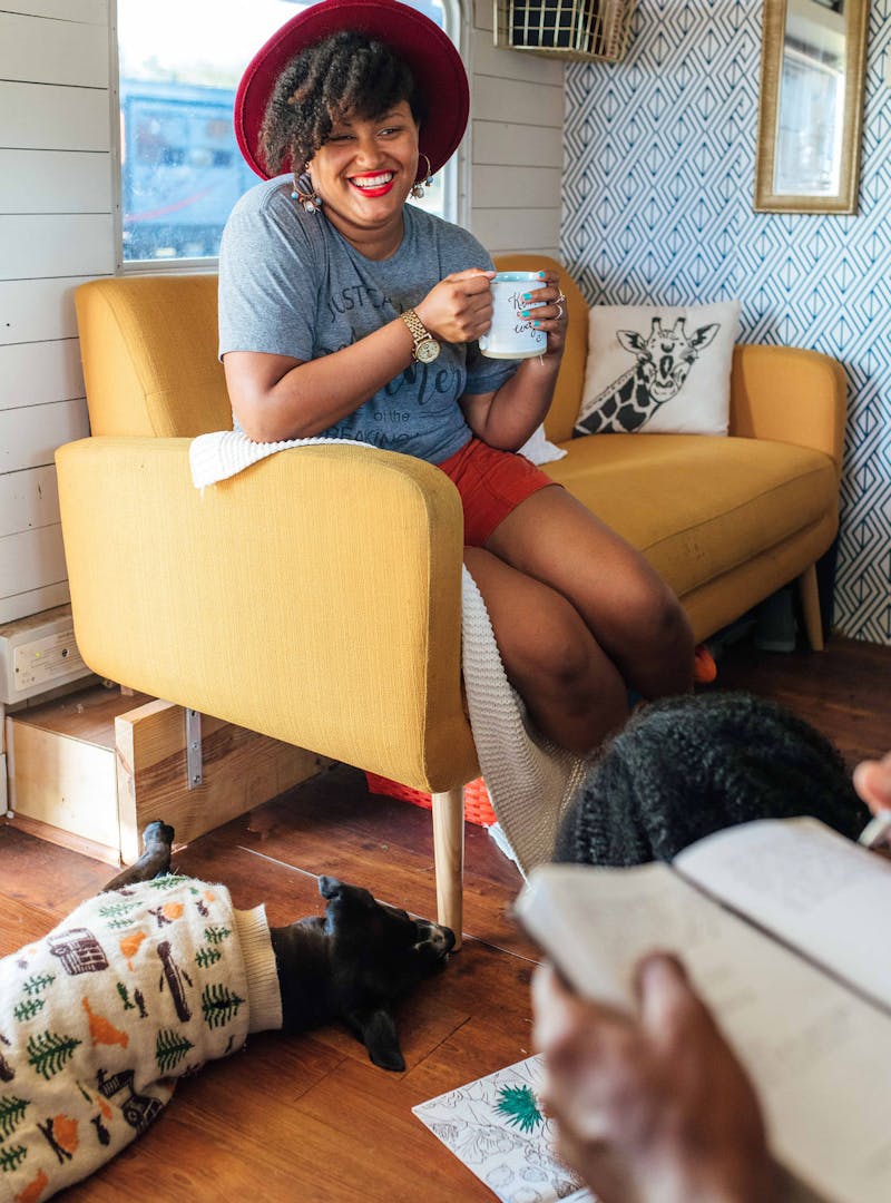 A mom sitting on a couch smiling at her family.