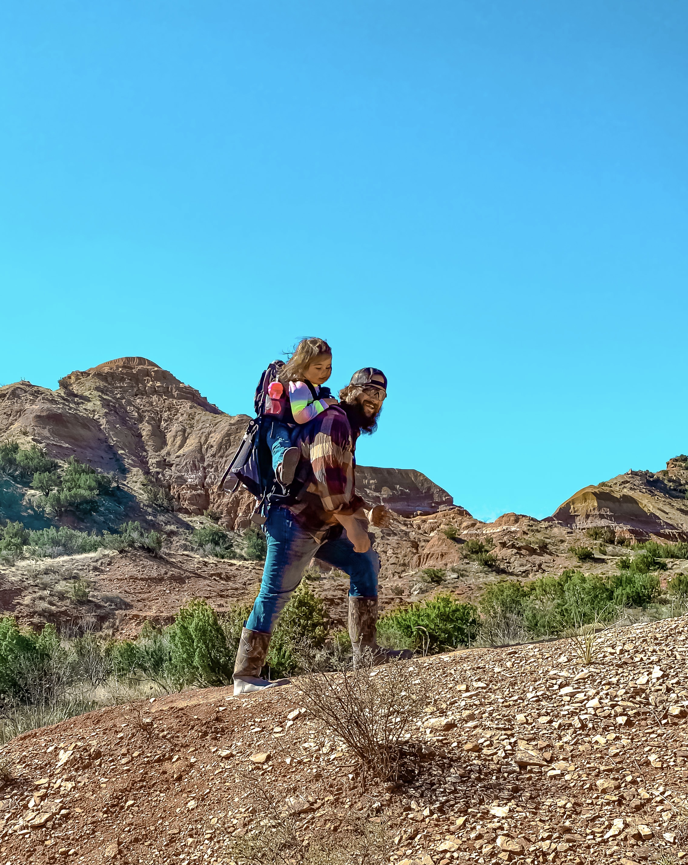 Sammy Seles' husband on a hike with their two year old daughter on his back.