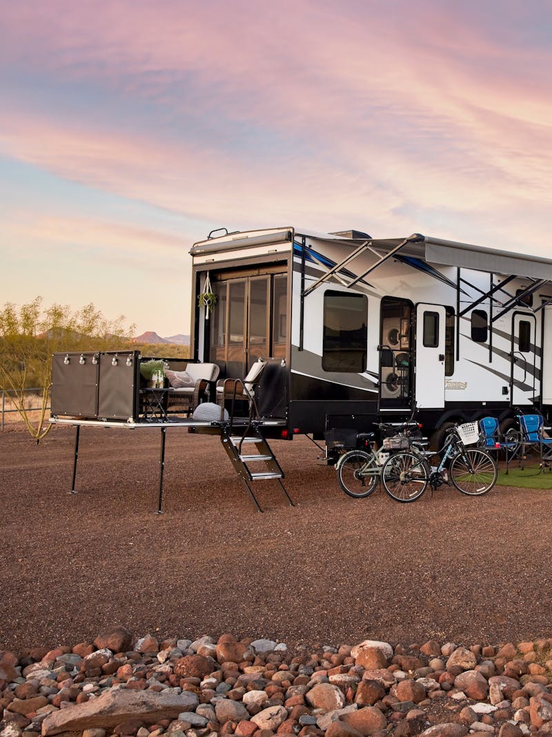 Robin, Warren and their family play outside of their Keystone Fuzion toy hauler RV.