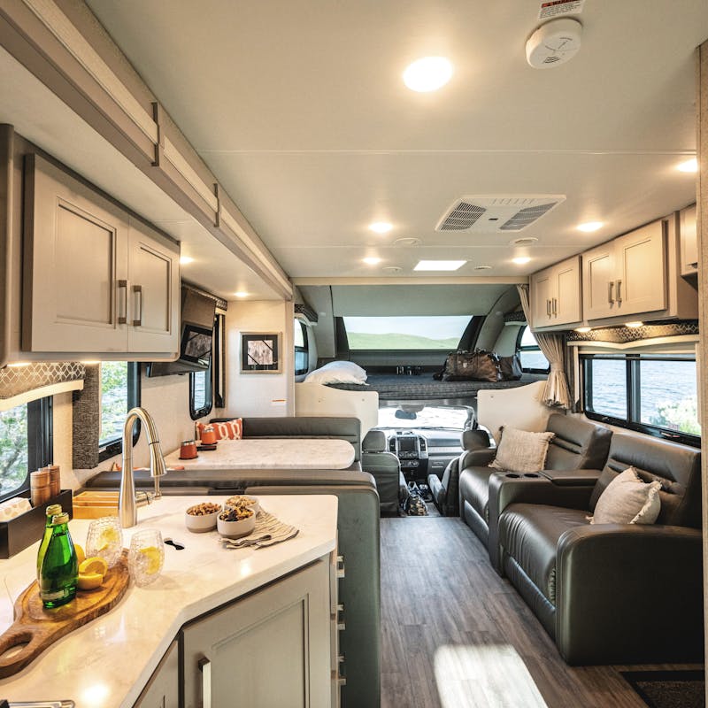 The kitchen, living room, and dining room inside a Thor Motor Coach Magnitude.