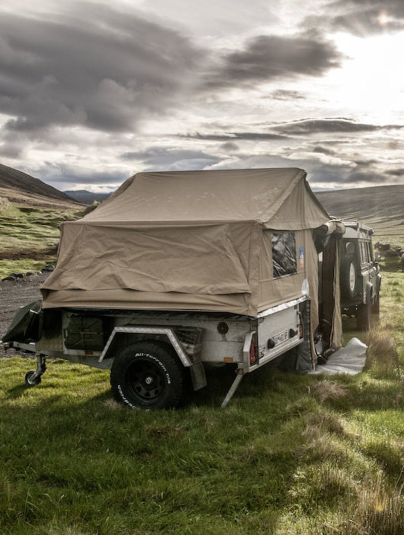 Expandable pop-up trailer sits in a field of green