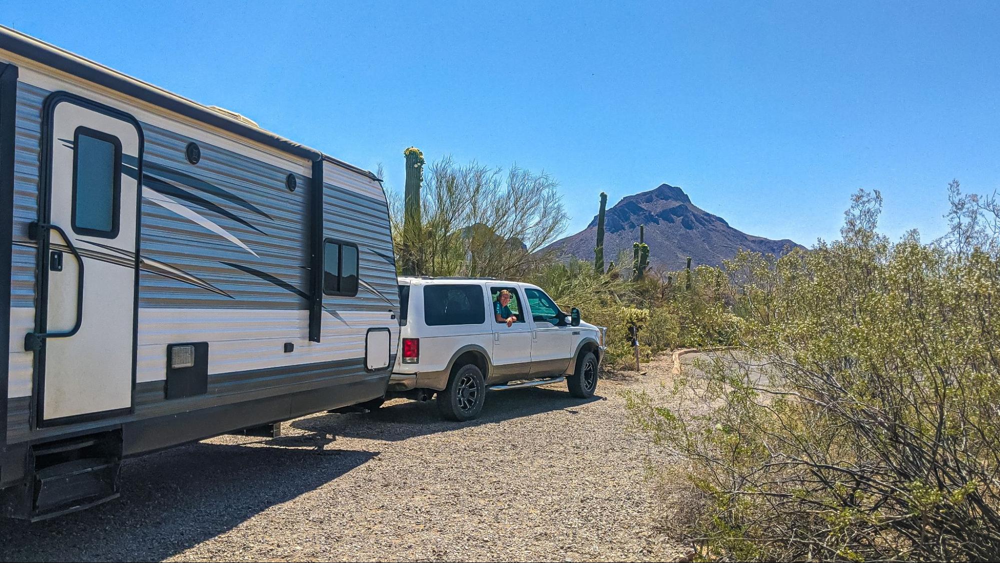 Renee Tilby's Jayco Jay Flight being towed by a truck in a desert landscape. 