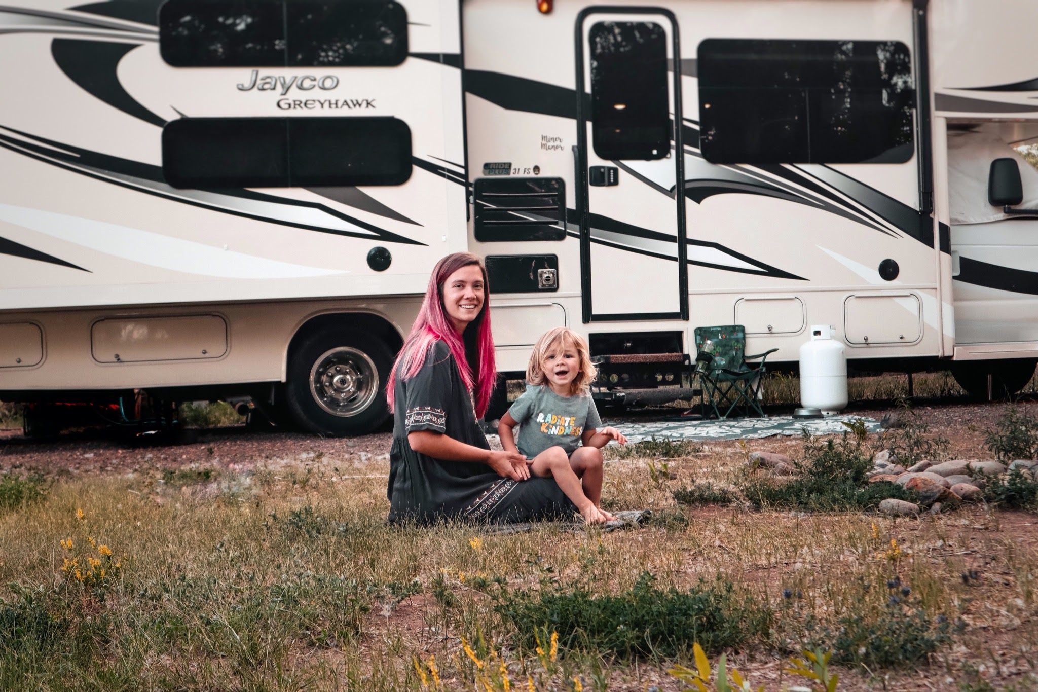 Holly Miner and her son sitting in front of their Jayco Greyhawk.