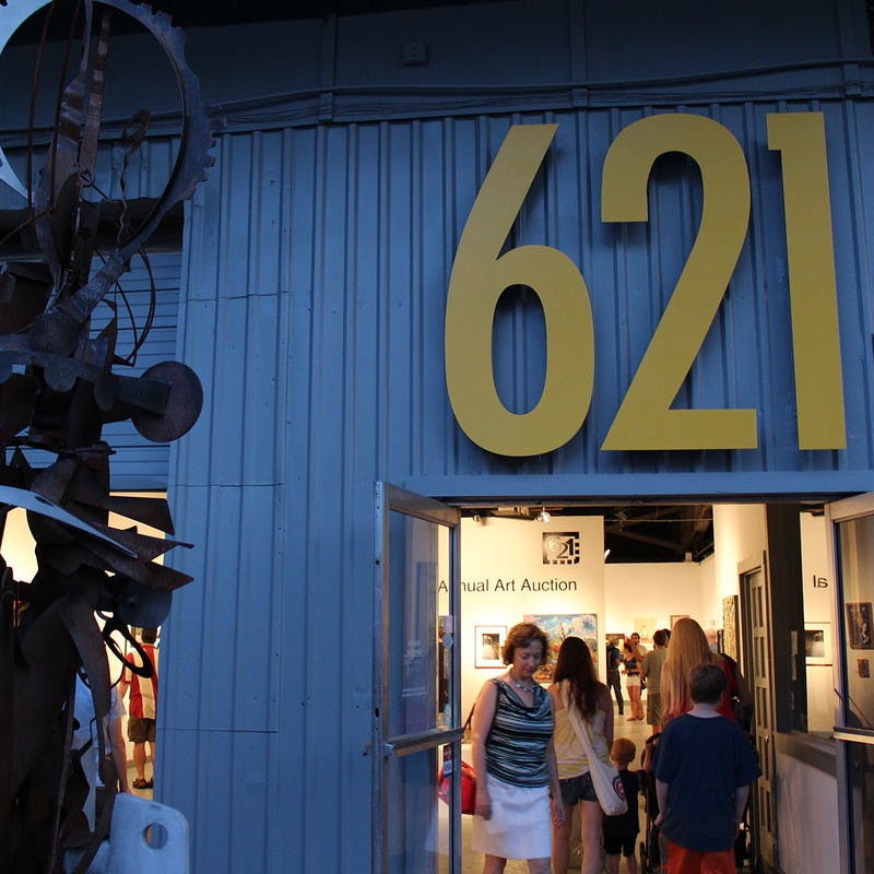 Blue industrial building with yellow address numbers and art statue out front in Railroad Square Art Park in Tallahassee, Florida.