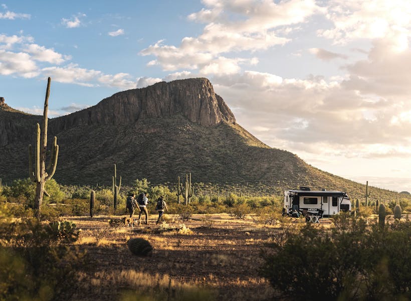 three men walking towards a Hitch travel trailer in the Arizona dessert