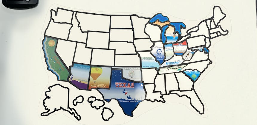 A sticker map on the back on an RV with different states colored in.