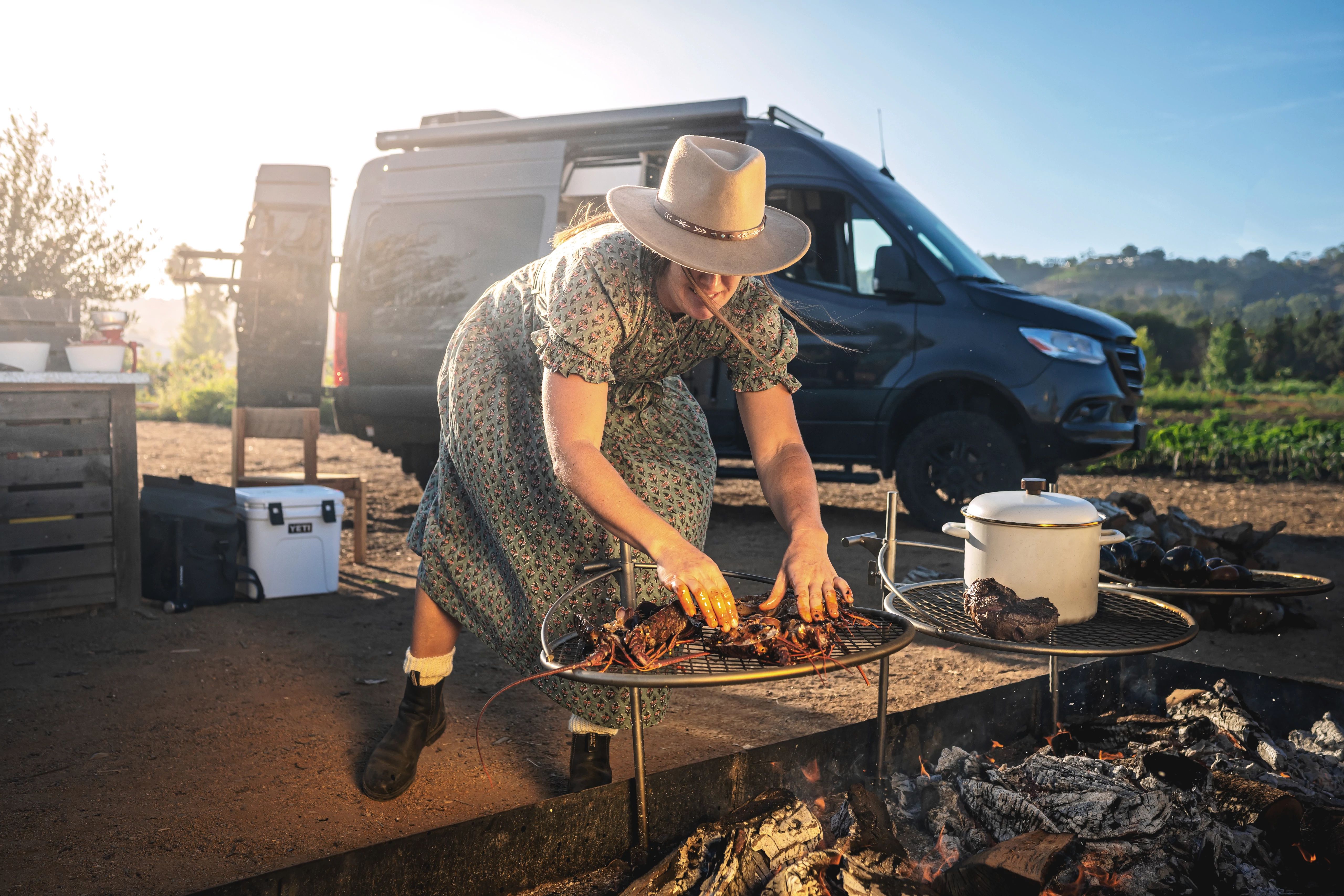 Sarah Glover placing lobster to cook over an open fire