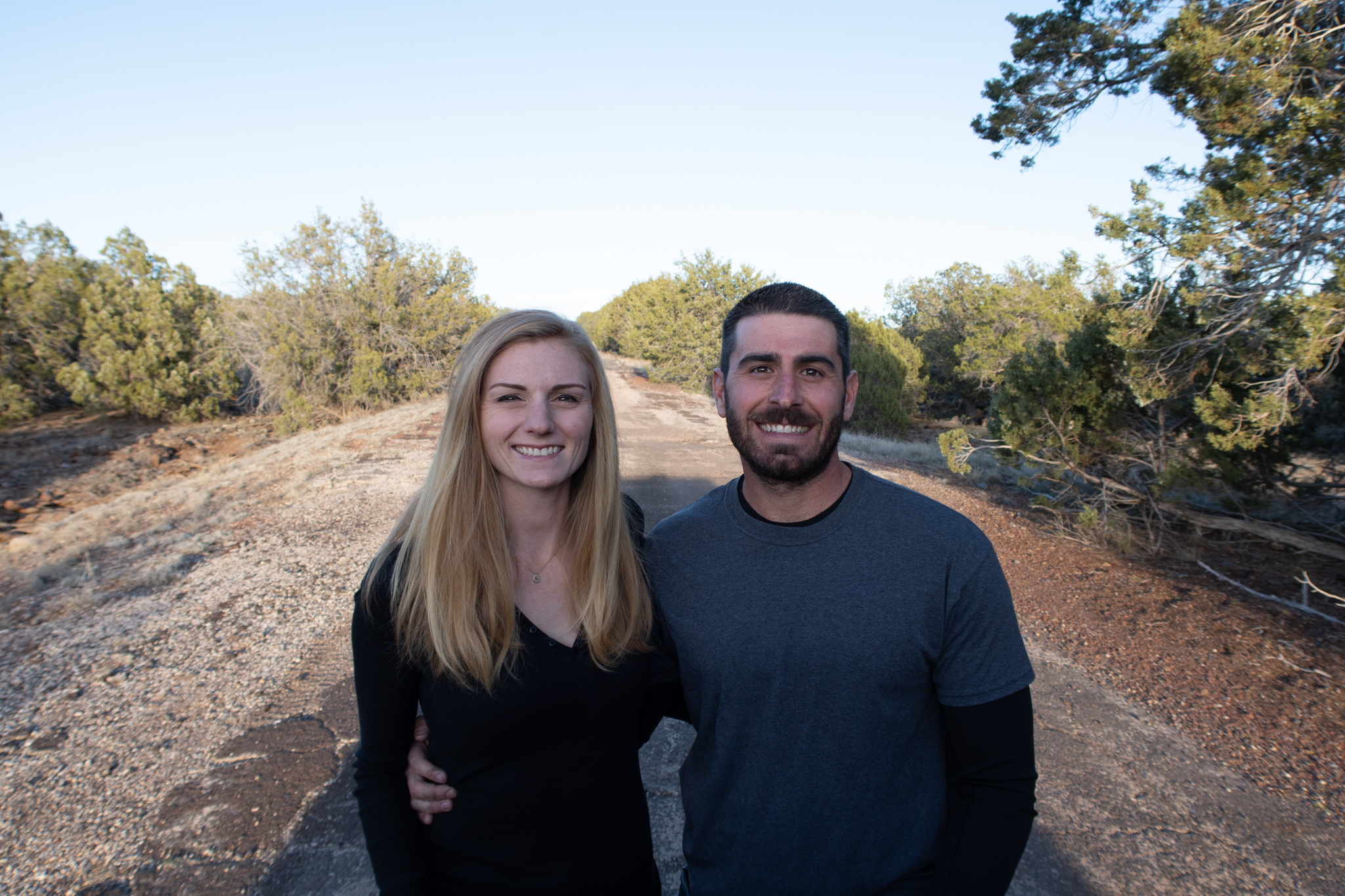 Jesse and Mel standing next to one another on a road outside.