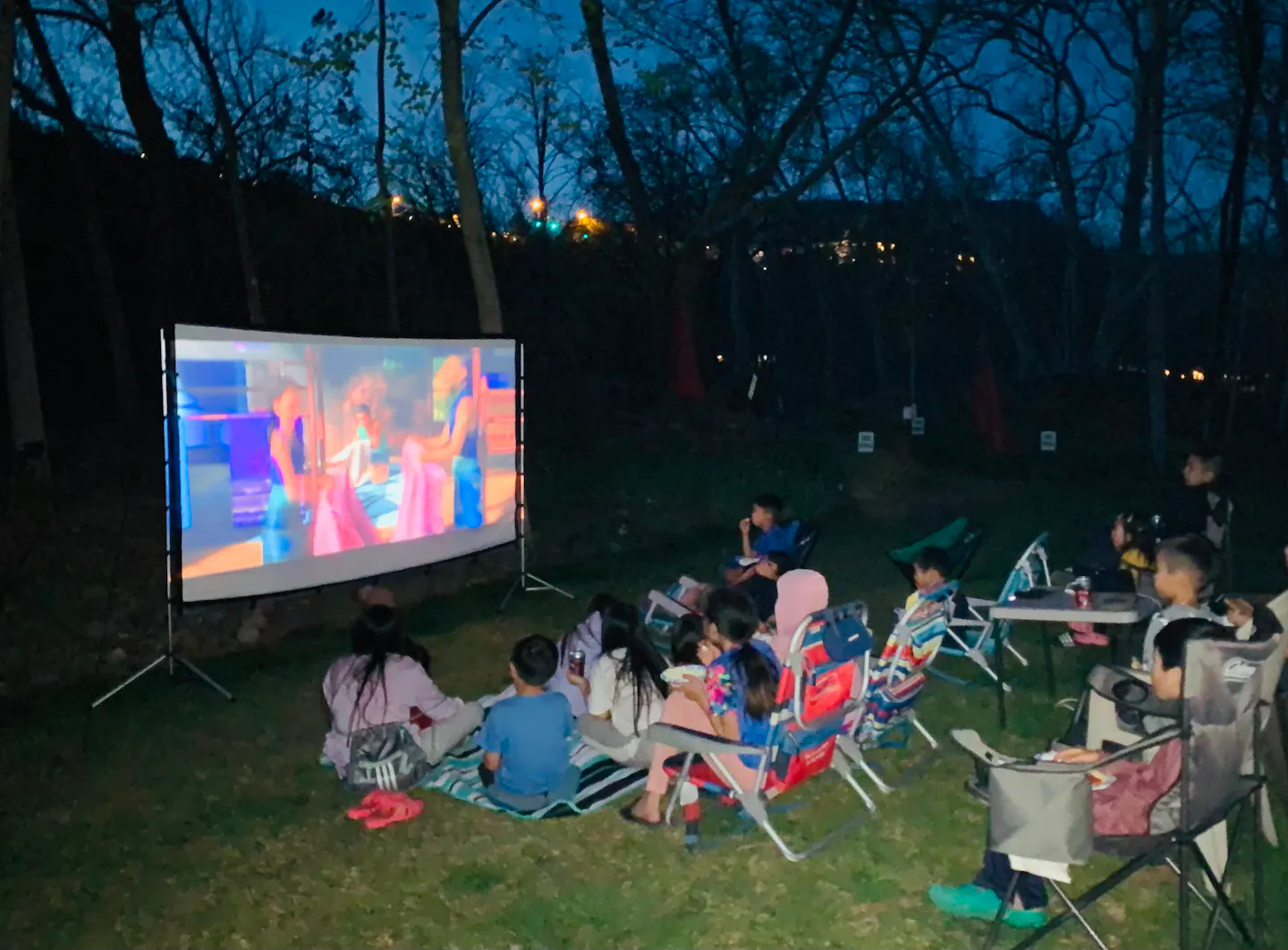 A group of children watching a movie outside at Brenda and Tiger's RV meetup 