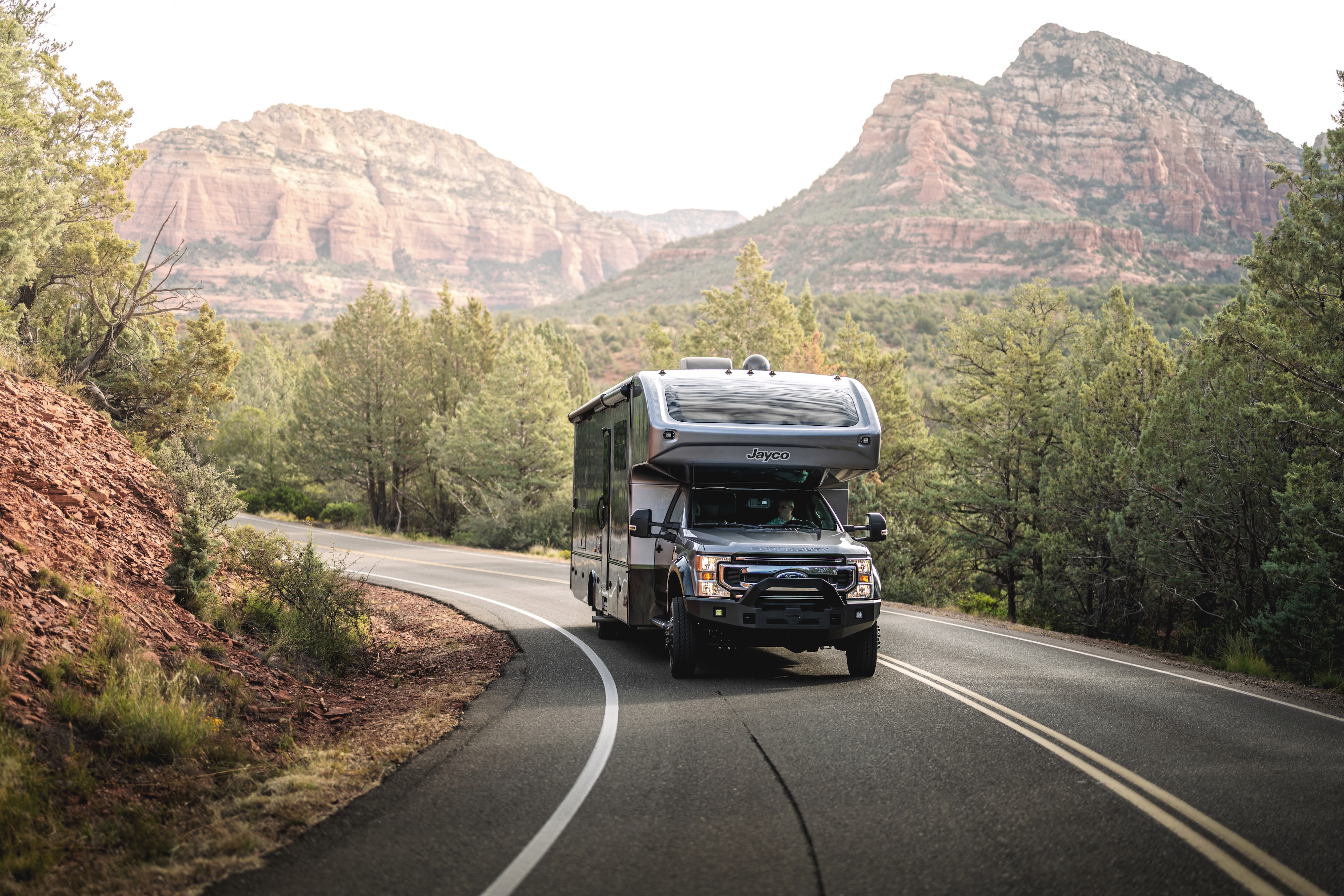 Jayco Seneca driving down the road through a mountain landscape