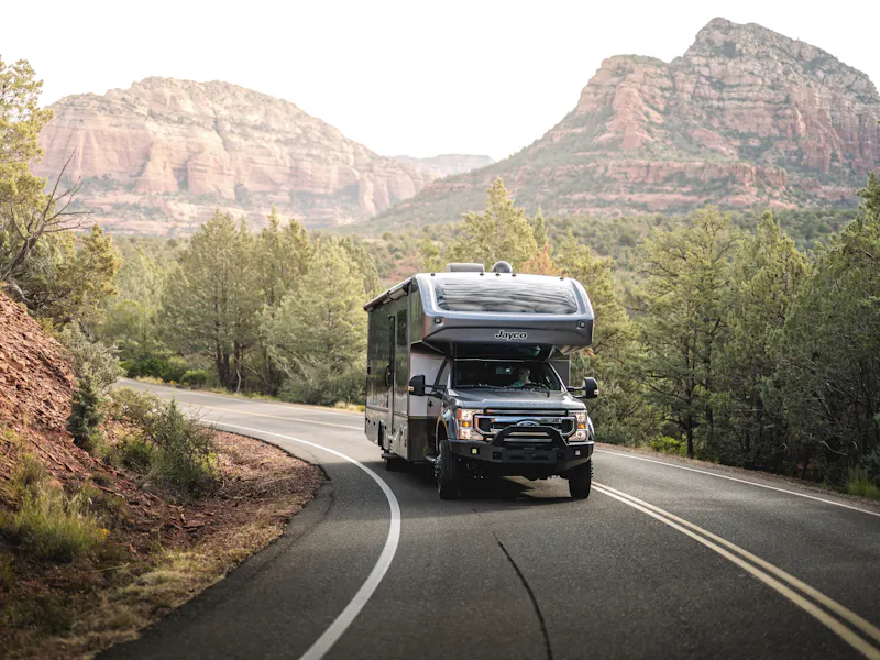 Jayco Seneca driving down the road through a mountain landscape