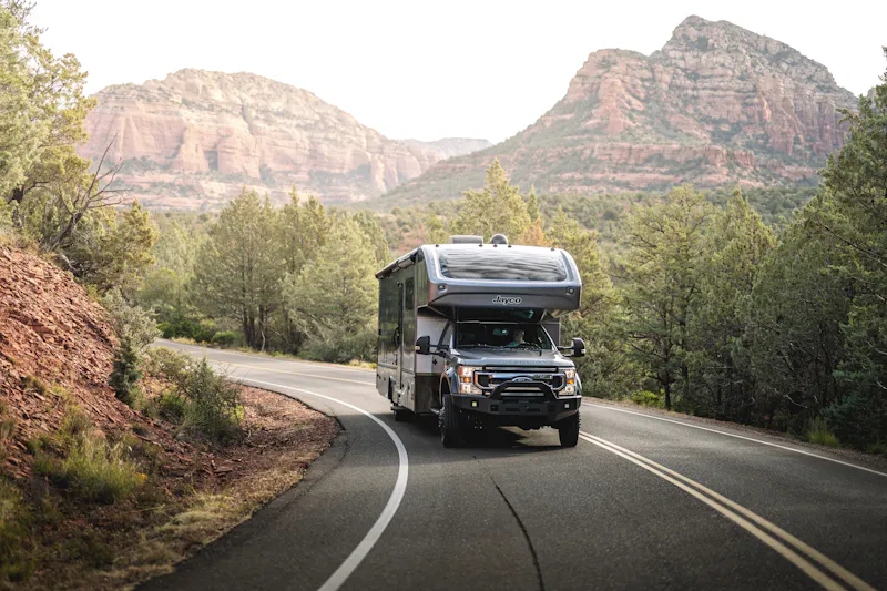 Jayco Seneca driving down the road through a mountain landscape